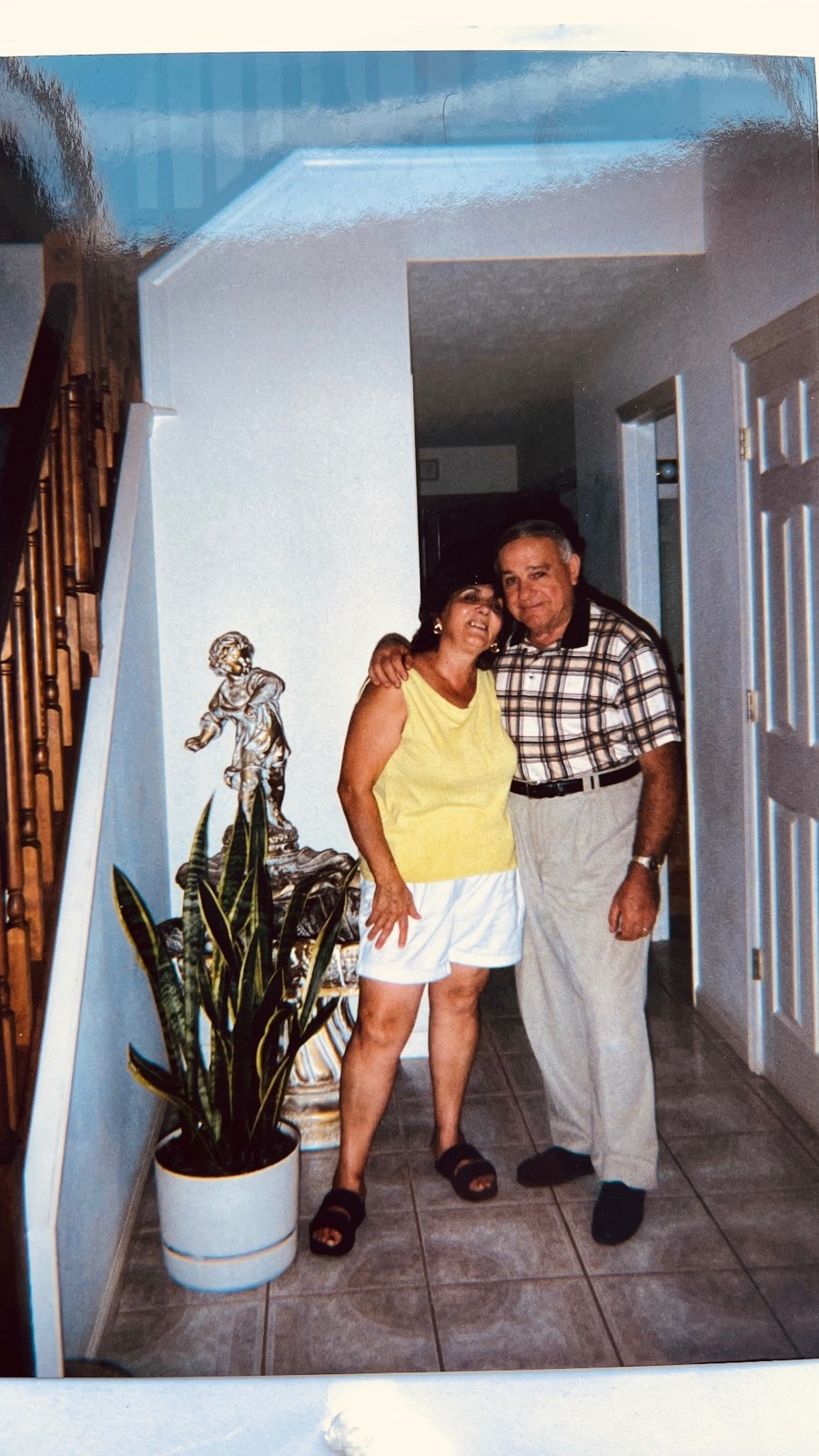 An older couple standing arm in arm in the hallway of their home