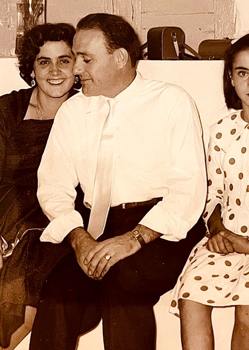 A close view of a smiling couple seated together at a family gathering