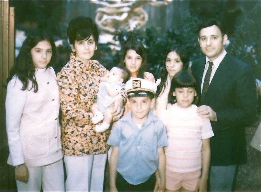 A family photograph of a mother, father and six children posed outdoors