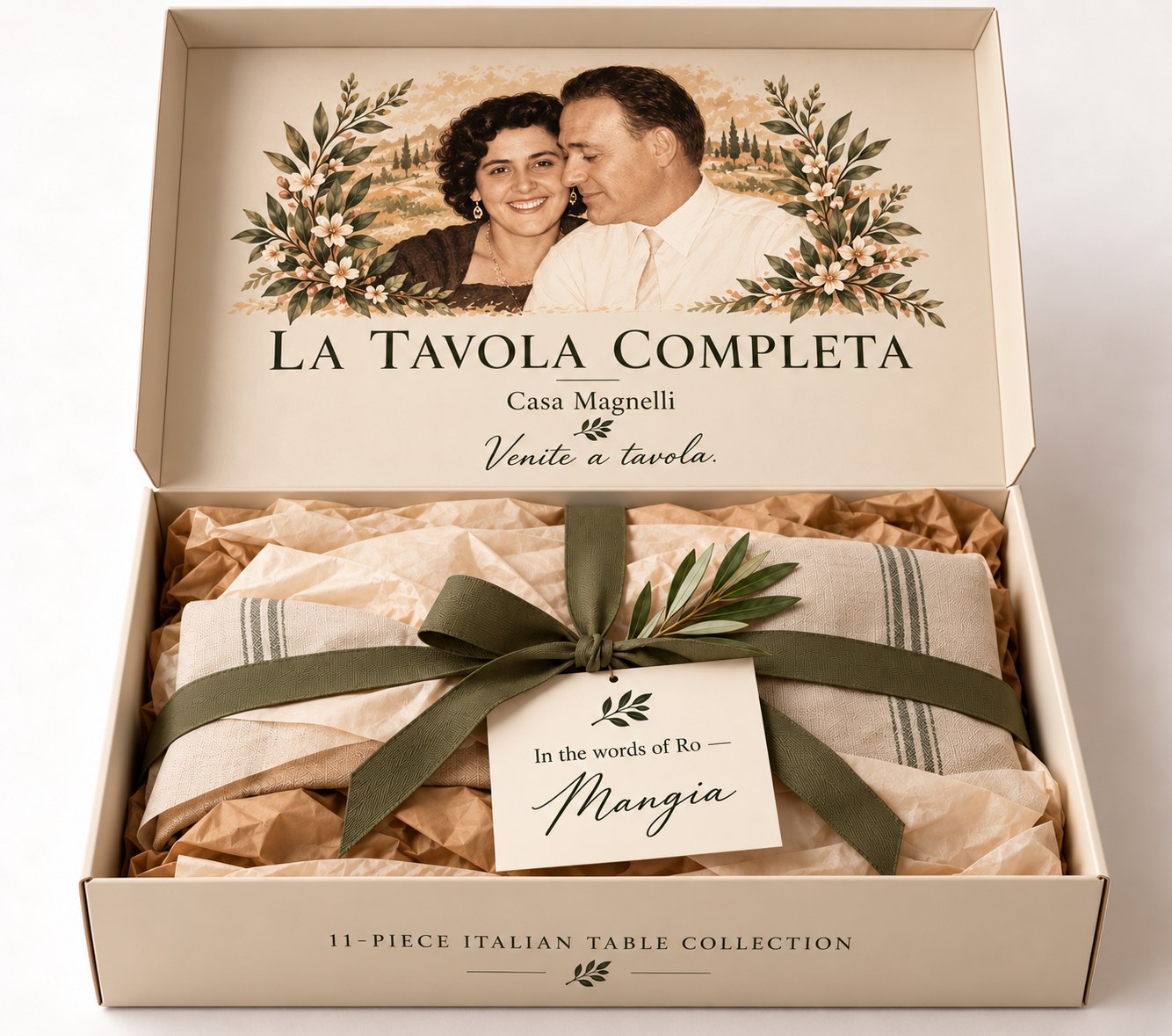 The La Tavola Completa box with its lid lifted, Ro and Ti's portrait inside the lid, the contents wrapped in tissue beneath an olive ribbon and a card that reads Mangia
